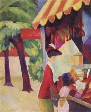  Aout Peintre - Une femme avec une veste rouge et un enfant devant le magasin de chapeau August Macke